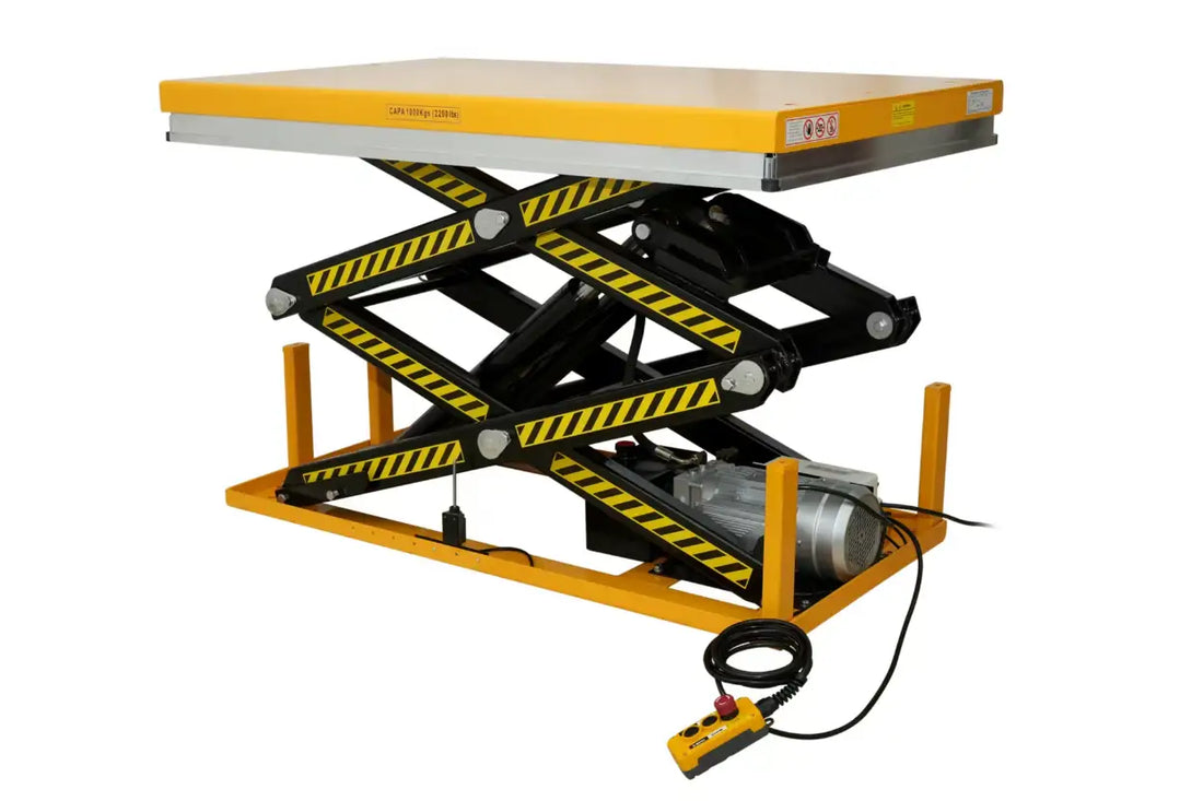 Stationary industrial electric hydraulic scissor lift table with yellow platform, black scissor legs featuring hazard warning stripes, and attached hand pendant control against a plain background