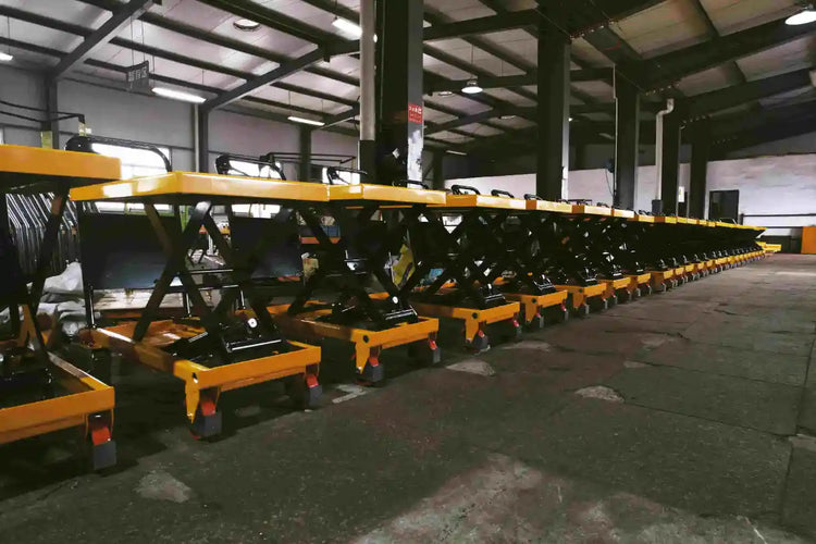 A long line of assembled yellow scissor lift carts inside the KINGRISE factory ready for quality inspection.